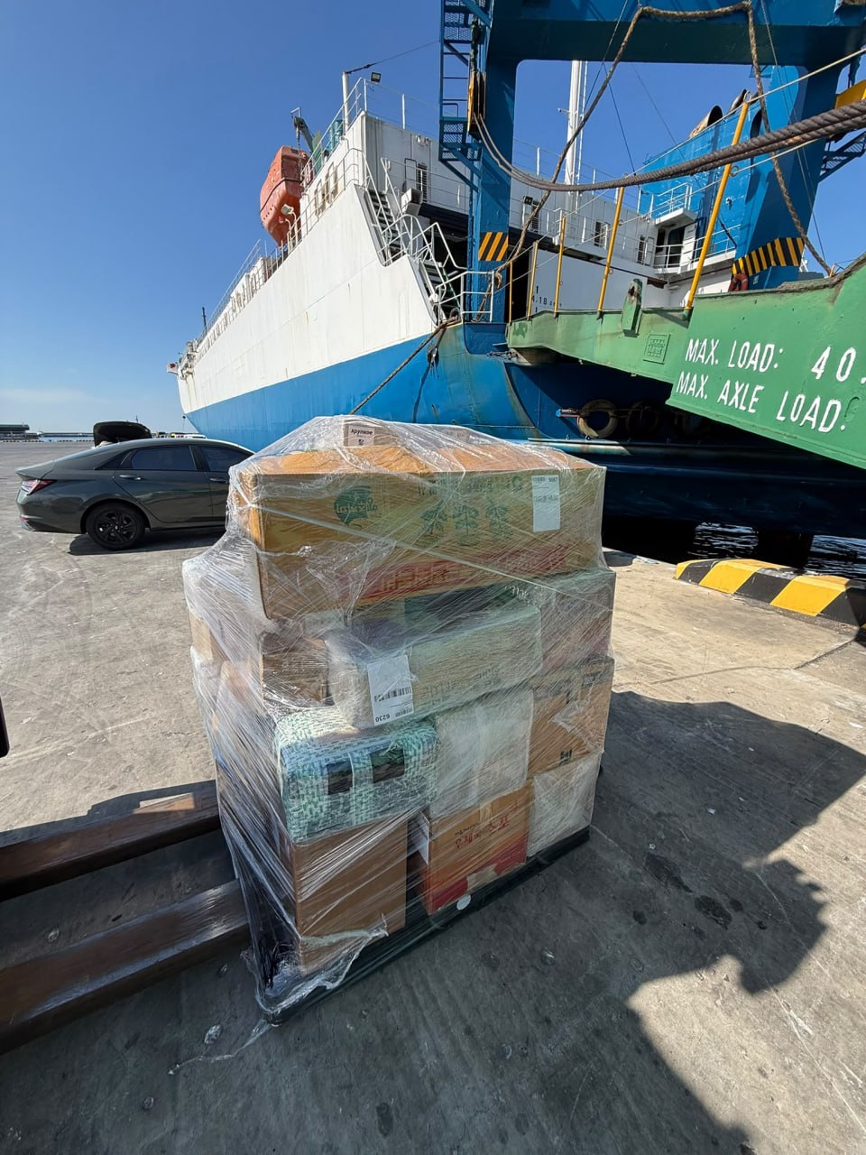 Wrapped pallet on forklift forks beside the vessel